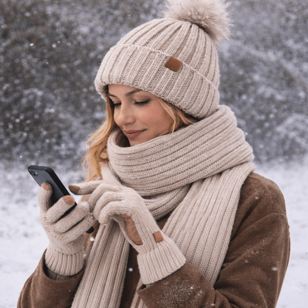 Woman in a cream knit beanie and scarf in the snow