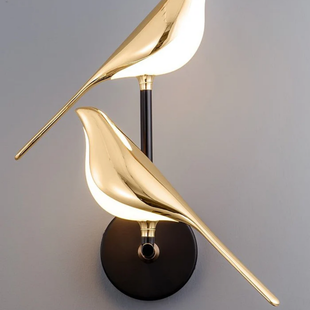 Moderne gullfarget vegglampe med fuglesilhuett