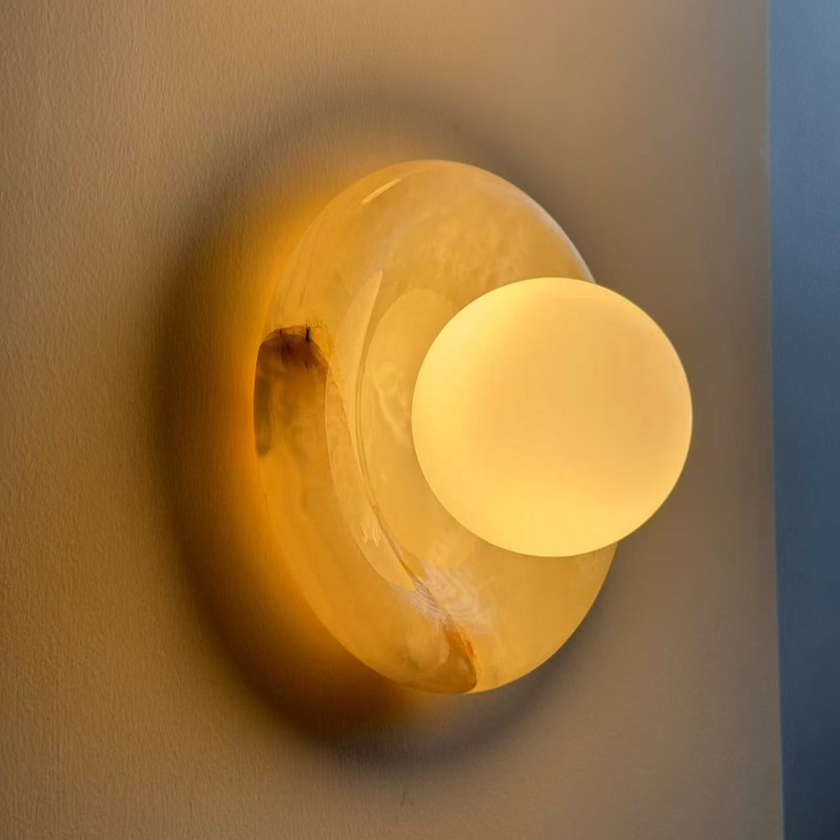 Vegglampe i travertin og marmor — rund skjerm i glass